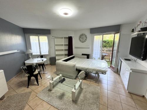 Cette chambre comprend un lit, une table et une cuisine. dans l'établissement Chez pierre-Olivier, à Saint-Julien-en-Genevois