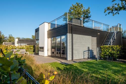 a modern house with a glass roof at Elite Cube mit Dachterrasse Meerblick und Strand in Hulshorst