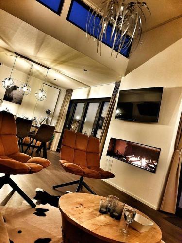 a living room with chairs and a fire place at Elite Cube mit Dachterrasse Meerblick und Strand in Hulshorst