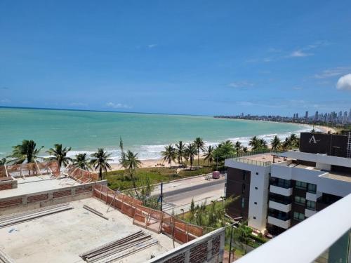 a view of the beach from the balcony of a building at Flat próximo ao mar, para até 4 pessoas in Cabedelo