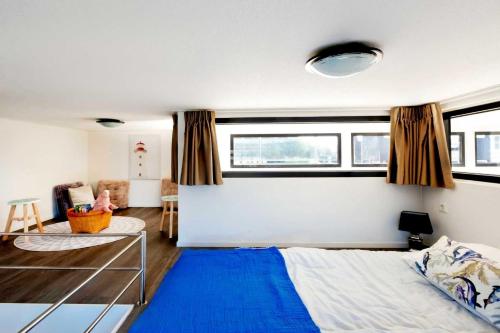 a bedroom with a bed and a blue rug at Elite Cube mit Dachterrasse Meerblick und Strand in Hulshorst