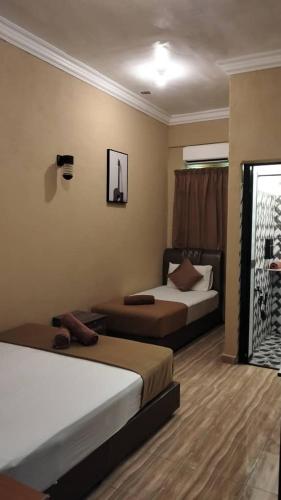 a hotel room with two beds and a window at Perhentian Mama's in Perhentian Island