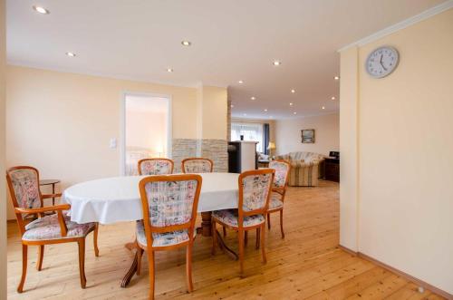 una sala da pranzo con tavolo e sedie bianchi di Bungalow Merla - Kemnitz a Dahme