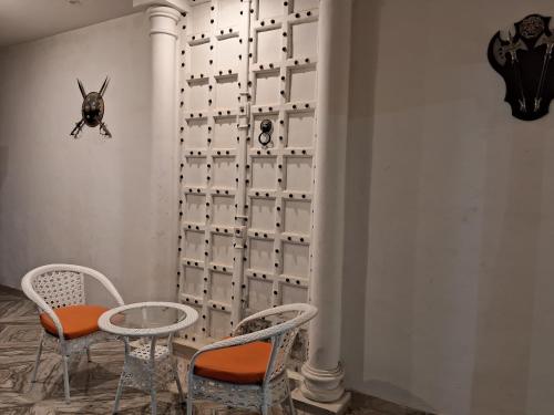 a room with two chairs and a table and a wall at Ashoka Hotel in Begusarai