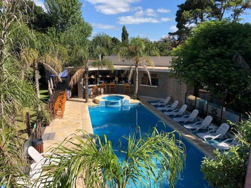 a swimming pool with lounge chairs next to a house at Complejo un Mundo Aparte in Mar de Ajó