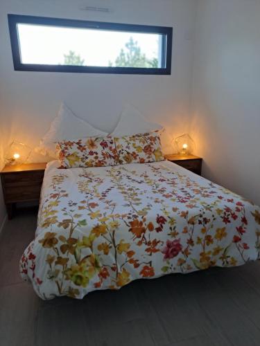 une chambre avec un lit avec une couette fleurie dans l'établissement Platin, à Saint-Palais-sur-Mer