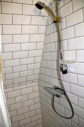 a shower in a bathroom with white tiles at Villa Betty in Visby