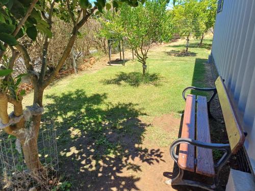 a bench sitting on a porch next to a tree at Tranquilo in Fray Bentos