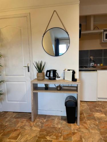a table in a kitchen with a mirror on the wall at Le Rêve de Claudia - Charmant Studio in Châteaudun