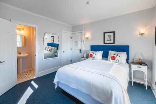 a blue and white bedroom with a bed and a sink at Grand Victorian an ICONA Boutique Collection in Spring Lake