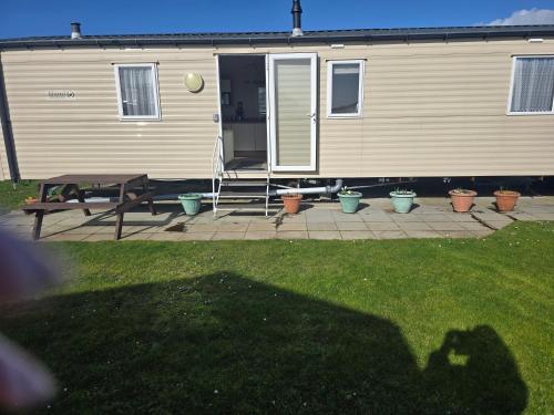 a shadow of a person standing in front of a trailer at Trecco bay birch in Newton