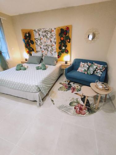 a bedroom with a bed and a couch and a table at Une virée à deux, gîte et spa in Guiscard