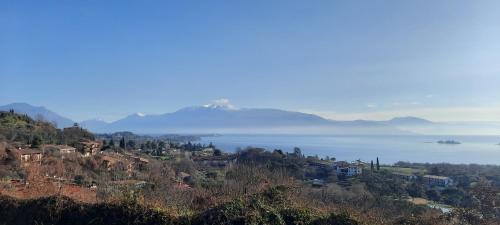 a town on a hill with a body of water at Elisa Holidays in Puegnano del Garda