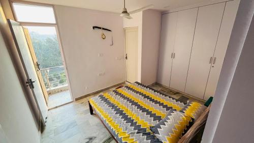 a room with a couch in a room with a window at Cozy nest 2bhk by LWB in New Delhi