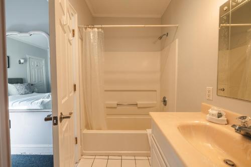 a white bathroom with a sink and a shower at Grand Victorian an ICONA Boutique Collection in Spring Lake