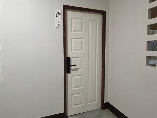 a white door with a black handle next to a room at V Rich วีริชเพลส ร้อยเอ็ด in Ban Non Muang