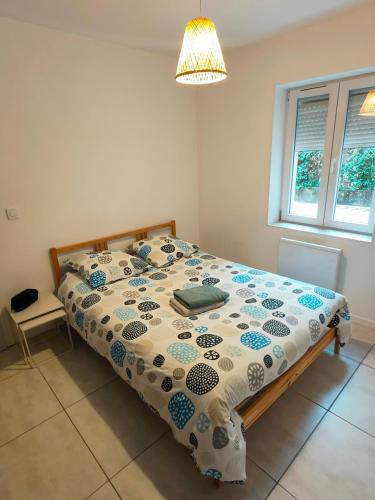 une chambre avec un lit avec une couette dessus dans l'établissement Joli appartement Urbain, à Cavaillon
