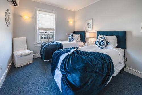 two beds in a room with blue and white at Grand Victorian an ICONA Boutique Collection in Spring Lake