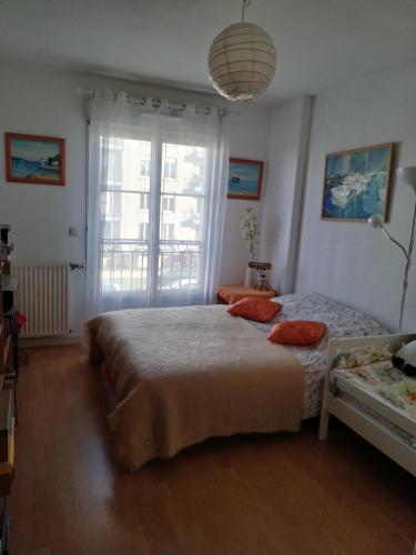 une chambre avec deux lits et une grande fenêtre dans l'établissement Appartement 65m2/2piéces/centre/parking privé, à Bordeaux