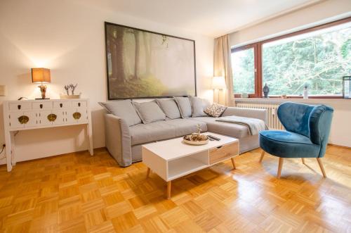 een woonkamer met een bank, een tafel en een stoel bij Ferienwohnung Amselnest in Bad Sachsa