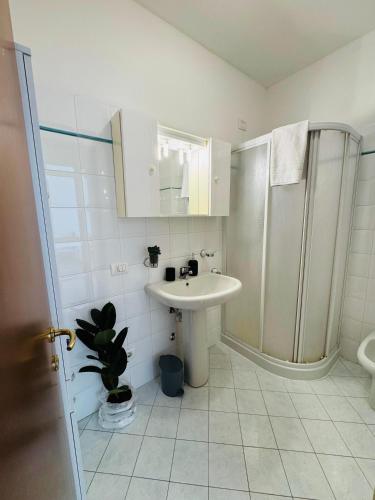 a white bathroom with a sink and a shower at Mimì apartment - Vicino a Gardaland in Peschiera del Garda