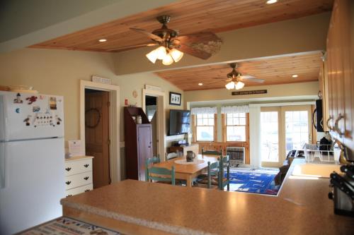 a kitchen with a refrigerator and a table with chairs at Beach Cottage in Saco