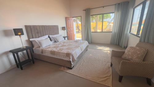 a bedroom with a bed and a chair and a window at Villa ArthurCC in Hikkaduwa