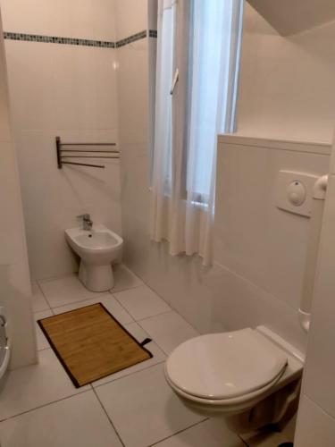 une salle de bain blanche avec des toilettes et un lavabo dans l'établissement Charmant Appartement T3 quartier historique, à Sète