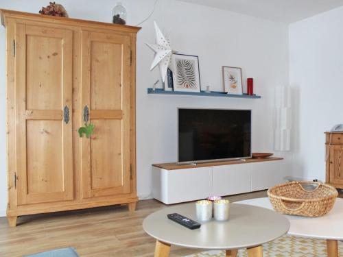 - un salon avec une télévision et une armoire dans l'établissement Ferienhaus Nr 128, Kategorie Komfort Plus L, Feriendorf Hochbergle, Allgäu, à Lechbruck am See