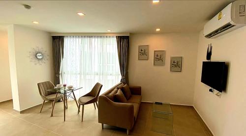 a living room with a couch and a table and a window at River View Active 3 in Bangkok