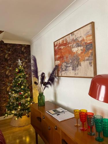 a living room with a christmas tree and a wooden table at Hideaway in Amble