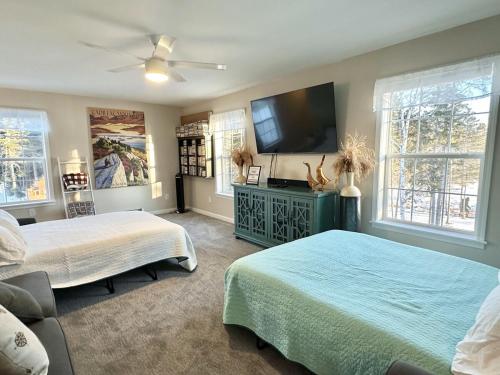 ein Schlafzimmer mit zwei Betten und einem Flachbildfernseher in der Unterkunft Waterfront Family & Pet Friendly Home with Hot Tub "Sandpiper Shores" in Gouldsboro