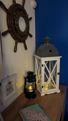 a table with a lantern and a mirror on a wall at Oh, Mon Bateau! No running water, bez tekuce vode in Belgrade
