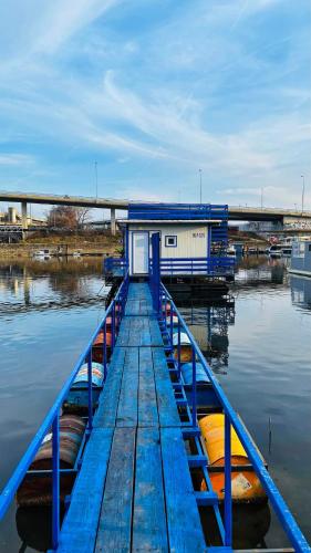 a blue dock with boats on a body of water at Oh, Mon Bateau! No running water, bez tekuce vode in Belgrade