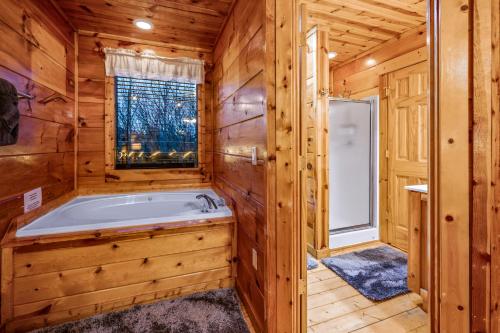 a jacuzzi tub in a log cabin bathroom at Bearadise-Private Cabin that Sleeps 8, with 3 Full Bathrooms, Pool Table, Board Games and Wet Bar in Sevierville