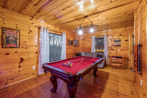 a room with a pool table in a cabin at Bearadise-Private Cabin that Sleeps 8, with 3 Full Bathrooms, Pool Table, Board Games and Wet Bar in Sevierville