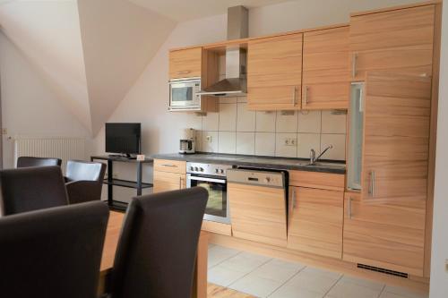 a kitchen with wooden cabinets and a stove top oven at App 4 Pers 2 Schlafzimmer mit eigenen Badezimmer 2 Balkonen alle mit Moselblick in Ediger-Eller