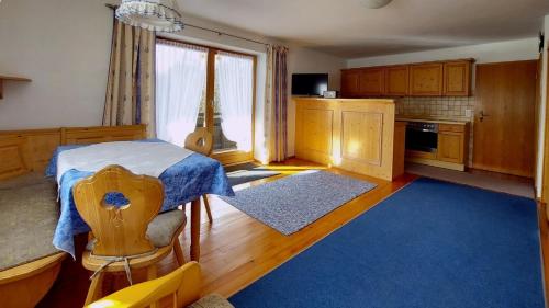 a kitchen with a bed and a blue rug at Ferienwohnung Nr 3, Lechbruck-Gründl, Allgäu in Prem