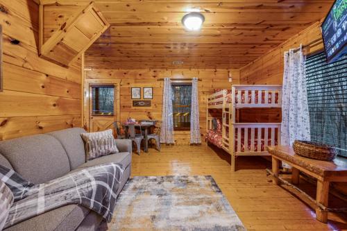 a living room with a couch and a crib in a cabin at Bearadise-Private Cabin that Sleeps 8, with 3 Full Bathrooms, Pool Table, Board Games and Wet Bar in Sevierville
