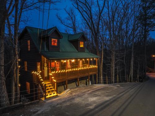 a house with christmas lights on the side of it at Bearadise-Private Cabin that Sleeps 8, with 3 Full Bathrooms, Pool Table, Board Games and Wet Bar in Sevierville