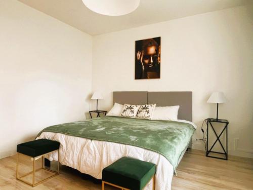 - une chambre avec un grand lit, deux tabourets et deux lampes dans l'établissement Chez Pascal, à Saint-Julien-en-Genevois