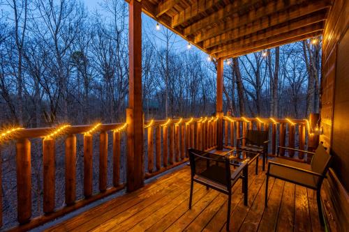a porch with lights and a table and chairs at Bearadise-Private Cabin that Sleeps 8, with 3 Full Bathrooms, Pool Table, Board Games and Wet Bar in Sevierville