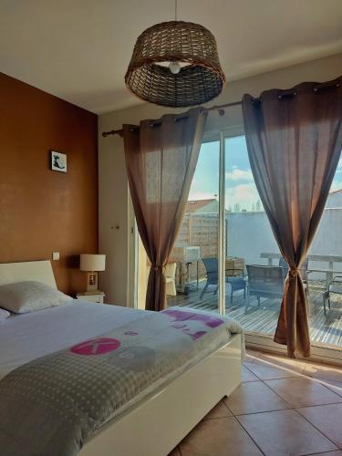 une chambre avec un lit et une vue sur un balcon dans l'établissement Jolie maison à la Cotinière classée 3 étoiles, à Saint-Pierre-dʼOléron