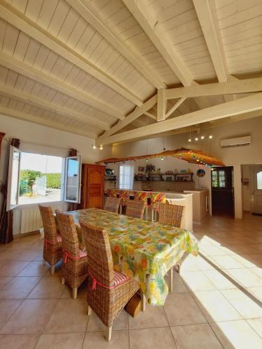 une grande salle à manger avec une table et des chaises dans l'établissement Jolie maison à la Cotinière classée 3 étoiles, à Saint-Pierre-dʼOléron