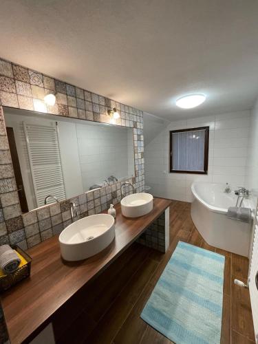 a bathroom with two sinks and a large mirror at Casa Sofia in Băile Homorod