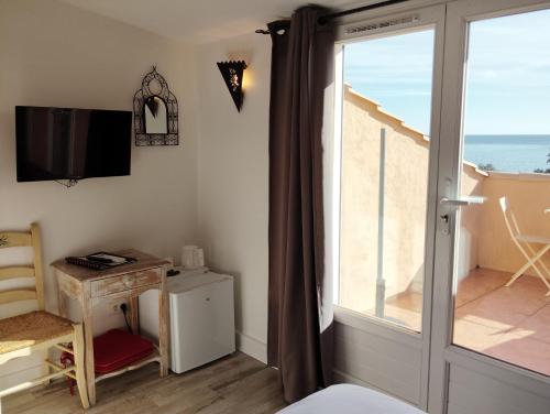 TV a/nebo společenská místnost v ubytování Hôtel Les Calanques
