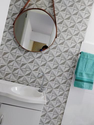 a bathroom with a mirror and a sink at Casinha no Centro in Santo Antônio do Pinhal