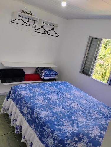 a bedroom with a blue bed and a window at Casinha no Centro in Santo Antônio do Pinhal