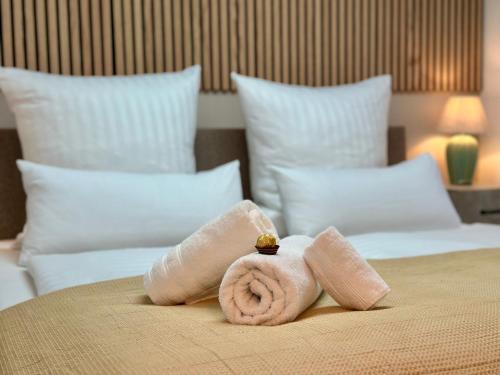 a towel on top of a bed with pillows at Bellevue Apartment - Zentrum - Netflix - Parkplatz in Bad Schandau