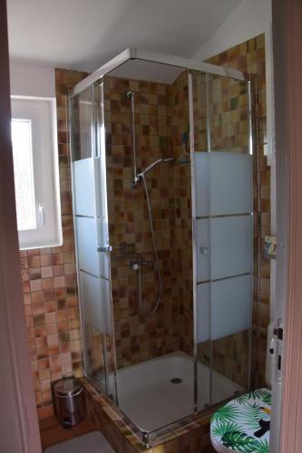 une douche avec une porte vitrée dans une salle de bain dans l'établissement La Grangette, à Joyeuse